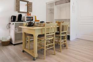 a kitchen with a table with chairs and a microwave at Suite Maraval Chez L'habitant in Trélissac