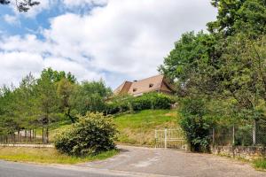 a house on a hill with a fence and a road at Suite Maraval Chez L'habitant in Trélissac