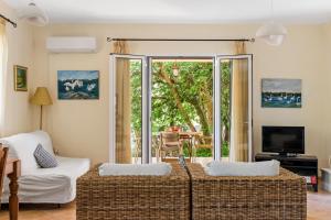 a living room with two wicker couches and a television at VK Villas in Apolpaina