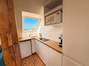 a small kitchen with a sink and a microwave at T2 lumineux, hypercentre Angers in Angers