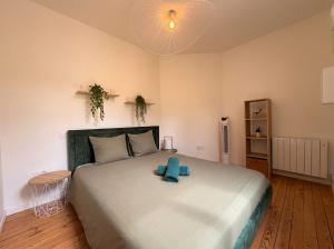 a bedroom with a large bed with a blue teddy bear on it at T2 lumineux, hypercentre Angers in Angers