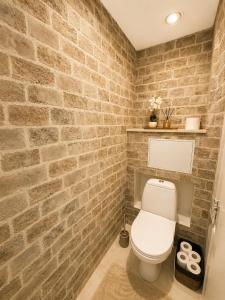 a bathroom with a brick wall and a toilet at Kaare in Uuemõisa