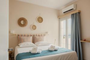 a bedroom with a bed with two towels on it at Cavo Notos Beach Hotel in Kavos