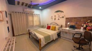 a bedroom with a bed and a desk at Homeland Stay in Ahmedabad
