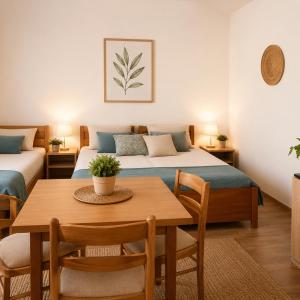 a bedroom with two beds and a table and chairs at Apartments Butkovic in Hvar