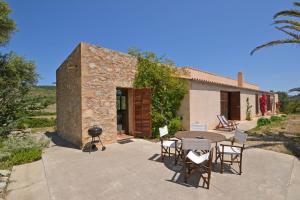 a patio with a table and chairs and a grill at Villa Font in Artá