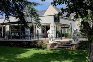 two white lion statues in front of a house at Mount Pleasant Hotel Self-Catering Cottages in Doncaster