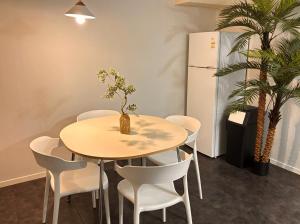 a table and chairs in a room with a refrigerator at Hotel Amy in Pup'yŏng-yŏk