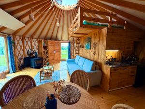 a living room with a table and a blue couch at Glamping Niebiańska Osada Jurty Dolnośląskie in Polanica-Zdrój
