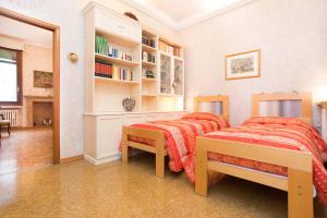a bedroom with two beds and a book shelf at Cà della Trifora in Venice