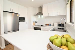 a kitchen with a bowl of fruit on a counter at Kingscote Getaway Kangaroo Island in Kingscote