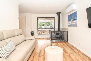 a living room with a couch and a table at Kingscote Getaway Kangaroo Island in Kingscote