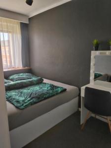 a small bedroom with a bed and a chair at APARTAMENTY & DOMKI Chełmsko Śląskie in Chełmsko Śląskie