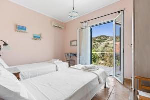two beds in a room with a large window at VK Villas in Apolpaina +49 photos