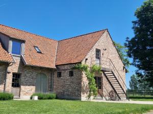 an old brick building with a red roof at Muntershof in Zottegem