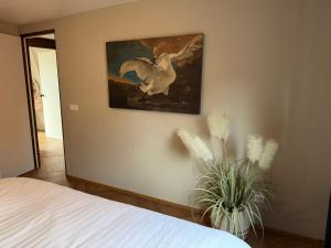 a bedroom with a painting of a horse on the wall at B&B The White House in Westzaan