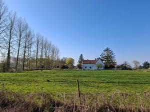 a large field with a house in the middle of it at Ferme Lenfant in Ville-Pommeroeul