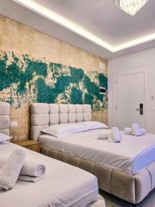zwei Betten in einem Zimmer mit einem Gemälde an der Wand in der Unterkunft Hotel Kosova in Velipojë + 55 Fotos