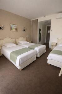 a group of three beds in a hotel room at Hôtel Le Mozart in Aix-en-Provence +43 photos