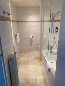 a bathroom with a shower and a bath tub at Hôtel Le Mozart in Aix-en-Provence