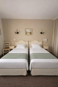 two beds sitting next to each other in a room at Hôtel Le Mozart in Aix-en-Provence