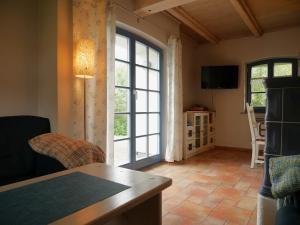 a living room with a large window and a table at Poeler Inselhaus in Kaltenhof