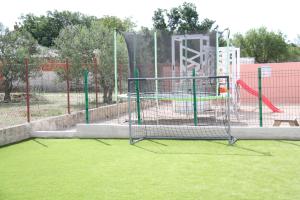 a batting cage in a park with a playground at MEL'S HOUSE in Benkovac