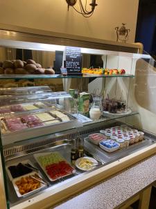 a display case in a bakery with lots of food at Hôtel Le Mozart in Aix-en-Provence