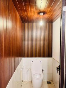 a bathroom with a toilet with a wooden wall at Mango Villa - Panama Near Arugam Bay in Panama