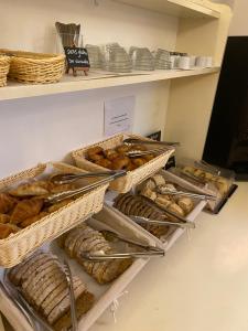 a shelf filled with baskets of bread and pastries at Hôtel Le Mozart in Aix-en-Provence