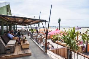 a group of people sitting on the deck of a restaurant at B&B The White House in Westzaan