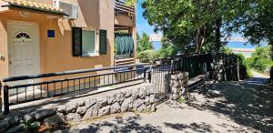 a house with a fence next to a gate at Lukovo Seafront Apartments in Lukovo