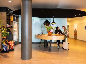 two women sitting at a table in a store at ibis Amsterdam Centre Stopera in Amsterdam