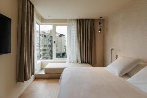 two beds in a hotel room with a window at Hotel Taro Santa Cruz in Santa Cruz de Tenerife