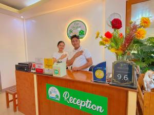 a man and a woman standing behind a counter at Casa Belina in Puerto Princesa City