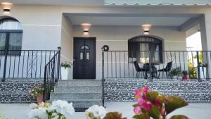 a house with a black door and stairs with flowers at Vila F&L in Vlorë