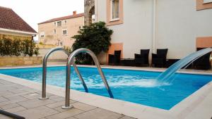 a swimming pool with a fountain in a building at Villa Ipera in Budva