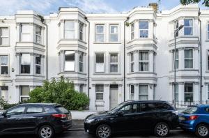 two cars parked in front of a large white building at Number 6 in Margate