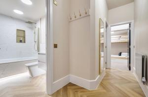 a bathroom with white walls and a toilet and a mirror at Number 6 in Margate +12 photos