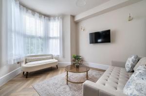 a living room with a couch and a tv at Number 6 in Margate