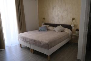 a bedroom with a bed with two pillows on it at Nel Corso del Sogni Sicily Center Rooms in Campofelice di Roccella +29 photos
