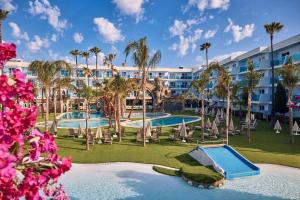 a view of a resort with a pool and palm trees at Pirates Village in Santa Ponsa