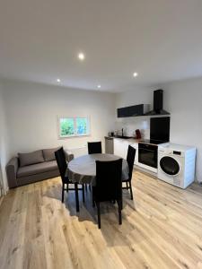 a living room with a table and chairs and a couch at Chez Julia in Brech