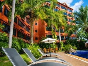 a resort with chairs and a pool and a building at Nova Park Hotel Pattaya in Pattaya