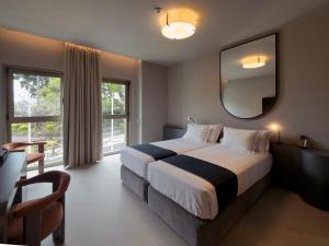 a hotel room with a large bed and a mirror at Moon & Sun Funchal in Funchal +63 photos