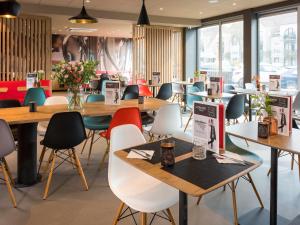 a restaurant with tables and chairs and flowers at ibis Aalst in Aalst
