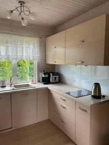 a kitchen with white cabinets and a sink and a window at Agroturystyka nad Jeziorem Orłowskim in Wielgie
