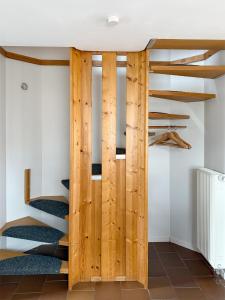 a wooden door in a room with stairs at Steuerbord in Prerow