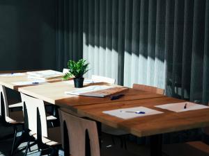 a long wooden table with a potted plant on it at Ibis Valladolid in Valladolid