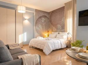 a bedroom with a large bed and a couch at City Gate - luxury suites in Bari